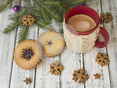 Winter morning, cup of coffee with knitted cup holders, gingerbread cookies with fir tree branches decorated with spruce Stock Photo