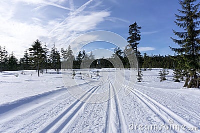 Winter mountain landscape with groomed ski track and blue sky in sunny day. Stock Photo