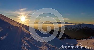 Splendid sunset. Winter mountain landscape. Sun, snow and hikers at high altitude - Ciucas Mountains, landmark attraction, Romania Stock Photo