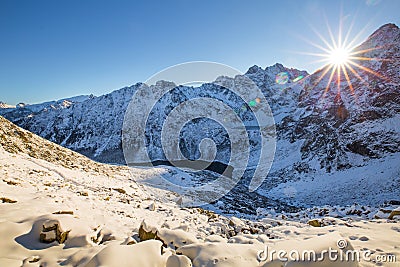 Winter mountains. Morning landscape of Tatra mountains with bright sun with sunbeams. Mountains hills covered with snow illuminate Stock Photo