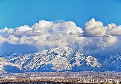 Winter Panoramic view of Snow capped Wasatch Front Rocky Mountains, Great Salt Lake Valley and Cloudscape from the Bacchus Highway Stock Photo