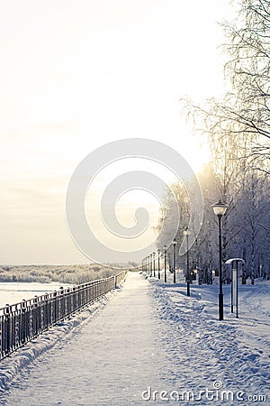 Winter park, snow-covered path, lanterns and a fence Stock Photo