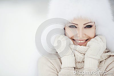 Winter portrait of beautiful smiling woman with snowflakes in white furs Stock Photo