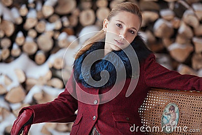 Winter portrait of blonde woman on firewood background Stock Photo