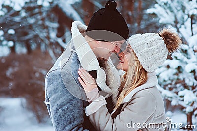 Winter portrait of happy romantic couple embracing and looking to each other outdoor in snowy day Stock Photo