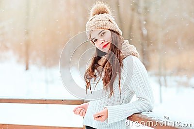 winter portrait of happy young woman walking outdoor in snowy park Stock Photo