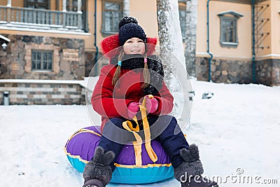 Winter portrait of a pretty girl. baby sledding tubing Stock Photo