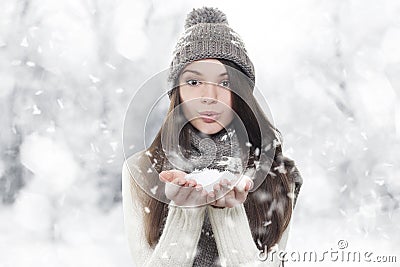 Winter portrait. Young, beautiful woman blowing snow Stock Photo