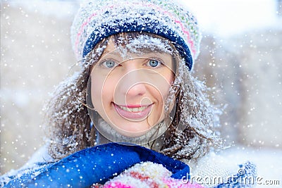 Winter portrait of a young woman. Beauty Joyous Model Girl touching her face skin and laughing, having fun in the winter park. Bea Stock Photo