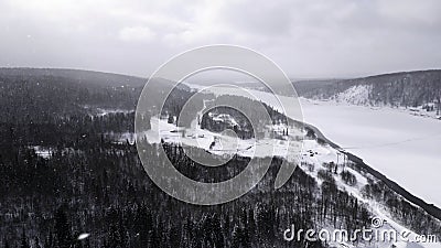 Winter resort hills covered by snow on a winter day. Clip. Mountain forest and ski slop.es and a frozen white river. Stock Photo