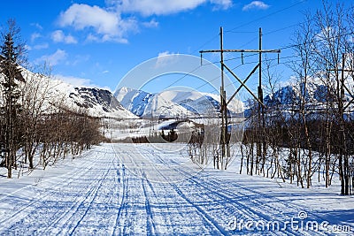 Winter road in the polar mountains and old electricity pillars Stock Photo