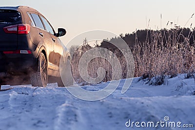 Winter rough frozen road in countryside with drifting car on slippery surface Stock Photo