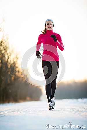 Winter running - Young woman running outdoors Stock Photo