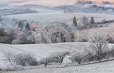 Winter Rural Landscape With With Frosted Wavy Plowed Fields, Trees In Hoarfrost And Old Windmill On The Hill. Beautiful Morning On Stock Photo