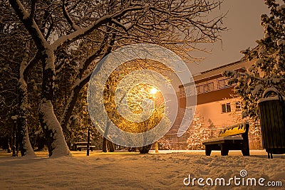 Urban residential house building, street light, park bench, garbage can, snow laden trees - Bucharest, Romania Stock Photo