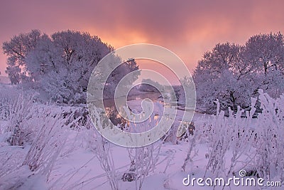 Winter scene at sunrise. Winter nature landscape. Frosty trees on river side. Amazing colorful sky at winter dawn. Scenic winter Stock Photo