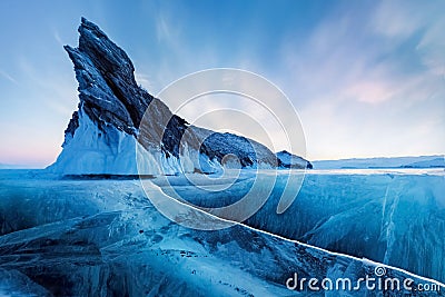 Winter Siberian landscape. Ogoy Island on Lake Baikal. Transparent patterned ice surface and mighty rock. Stock Photo