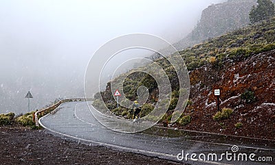Winter snowfall in Teide National Park, Tenerife, Canary Islands, Spain.Biking on the road through snowy volcanic landscape. Stock Photo
