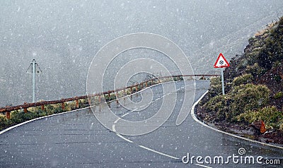 Winter snowfall in Teide National Park, Tenerife,Canary Islands, Spain.Icy road through snowy volcanic rocky desert landscape. Stock Photo