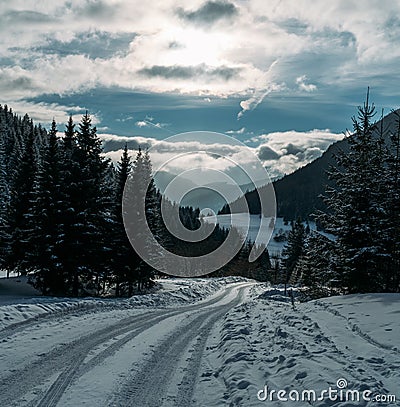 Winter snowy landscape view of a countryroad leading through spruce mountain forest in Slovakian Low Tatry mountains Stock Photo