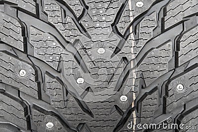 Winter studded tire background. Winter car tires texture background. Tire stack background. Tyre protector surface close up. Stock Photo