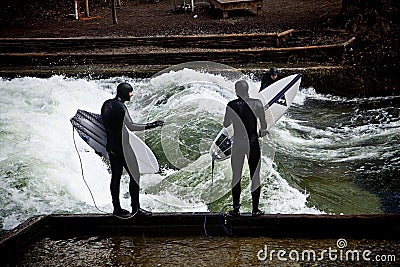 Winter surfing in diving suit on the Eisbach river at Englische Editorial Stock Photo