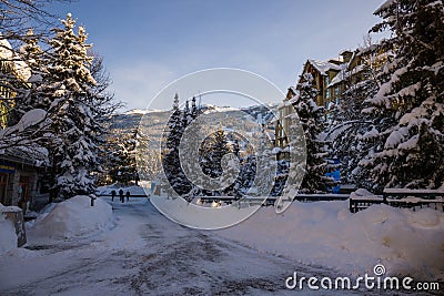 A winter tale - a sunny day for Christmas. Snow-covered streets, houses, sun rays, people walking along the pedestrian zone. ski Editorial Stock Photo