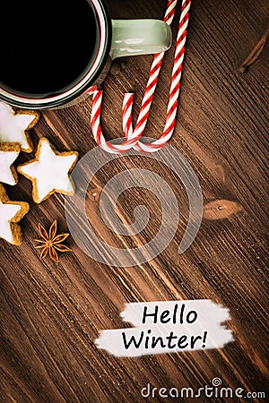 Winter theme. Hot steaming cup of glint wine with spices, anise, cookies in a shape of star, red candies, pepper on wooden Stock Photo