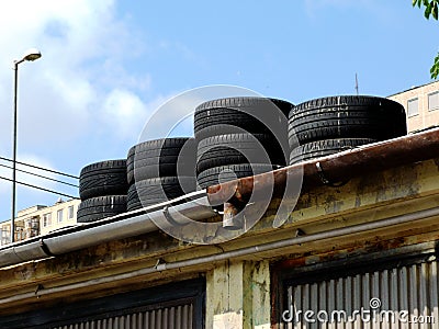 winter tires stored on top of decaying garage roof Stock Photo