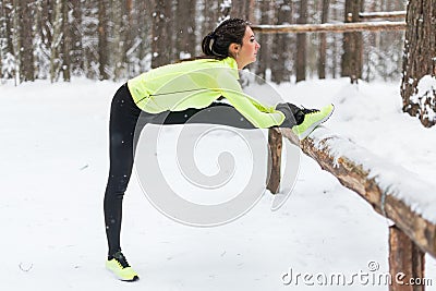 Winter training Fitness model athlete girl warm up stretching her hamstrings, leg and back. Stock Photo