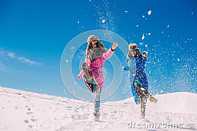 Winter, two girls having fun in the snow in the mountains Stock Photo