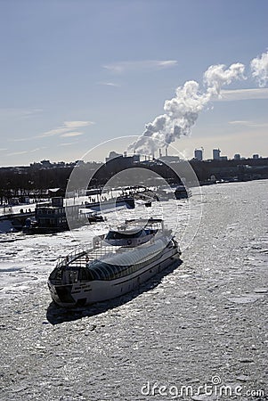 Winter view of the Moscow river embankment and cruise yacht sailing on iced water Editorial Stock Photo