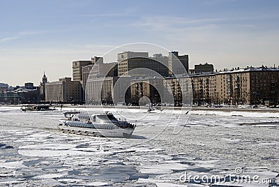 Winter view of the Moscow river embankment and cruise yacht sailing on iced water Editorial Stock Photo