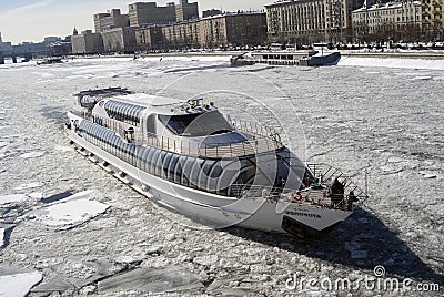 Winter view of the Moscow river embankment and cruise yacht sailing on iced water Editorial Stock Photo