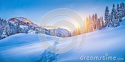 Winter wonderland in the Alps with mountain chalet at sunset Stock Photo