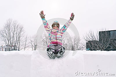 Winter young teenager portrait. Beauty Joyful Model Girl raising hands, spinning and laughing, having fun in winter park. Stock Photo