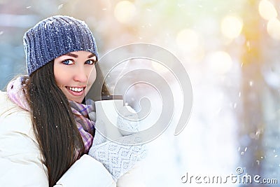 Winter young woman portrait. Beauty Joyful Model Girl holding thermocup with hot tea and smiling, having fun in winter Stock Photo