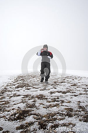 Wintertime: time to have fun in a ski resort. Snow, mountaintop, haziness, skier. Stock Photo