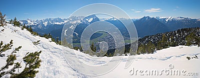 Wintry hiking path at Wank mountain, view to Zugspitze and tourist resort Garmisch-Partenkirchen Stock Photo