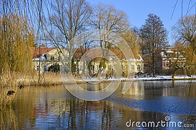 A wintry scene in Berlin, Germany, district Lichtenrade, with a village pond in the foreground and a small manor in the background Stock Photo