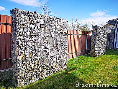 Wire and stone fence. decorative building made of stone Gabion Stock Photo