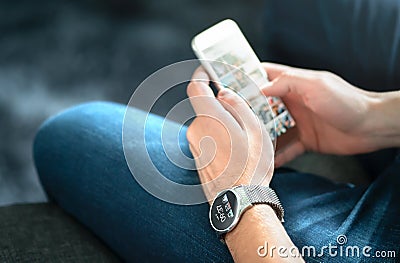 Wireless connection between smart watch and mobile phone. Man using wearable gadget and digital app. Stock Photo