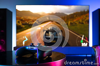 Wireless Joystick On Foreground, Tv Set With Racing Video Game On Background. 3d rendering. Stock Photo
