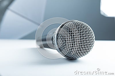 A wireless microphone lying on a white table. Against the background of studio equipment, soft boxes Stock Photo