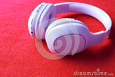 Wireless Pink Headphones, isolated in red fabric background, use for listening music and watch movie or exercise, earphones. Stock Photo