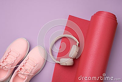 Wireless pink headphones, red mother pair of sports sneakers for sports, fitness and yoga Stock Photo