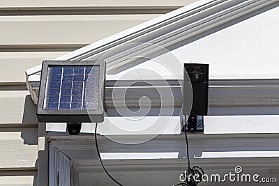 A wireless security surveillance camera with motion sensor on top of the front door frame Stock Photo