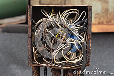 wires interconnected in a rusty old crowded box for wires. Stock Photo