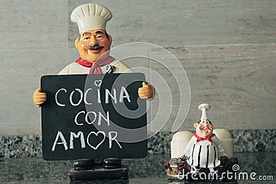 Wise cook with blackboard in hand that says kitchen with love Stock Photo