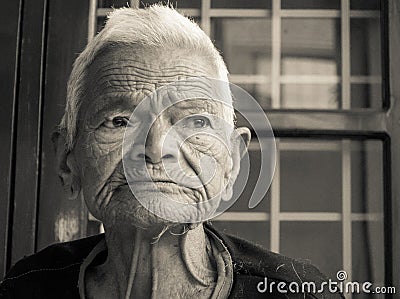 Wise elderly Indian woman in her 80s, showcasing a face with wrinkles and short, white hair. A captivating portrayal of age and Editorial Stock Photo